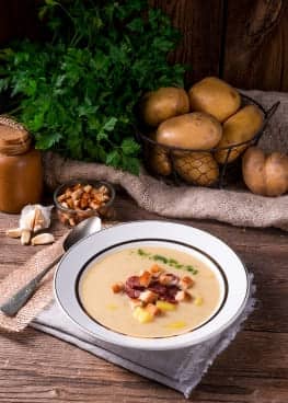 Potato soup with crispy bacon and crunchy nuts, a comforting and flavorful dish.