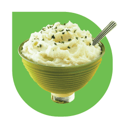Mashed potatoes in a green bowl with a spoon, a classic side dish .