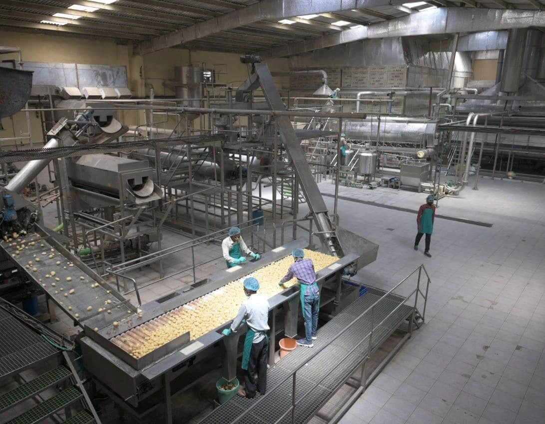 A factory assembly line with workers diligently working on a conveyor belt to manufacture products efficiently.