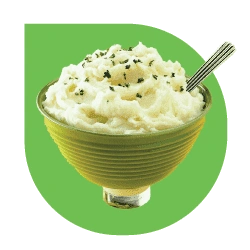 Mashed potatoes in a green bowl with a spoon, a classic side dish .