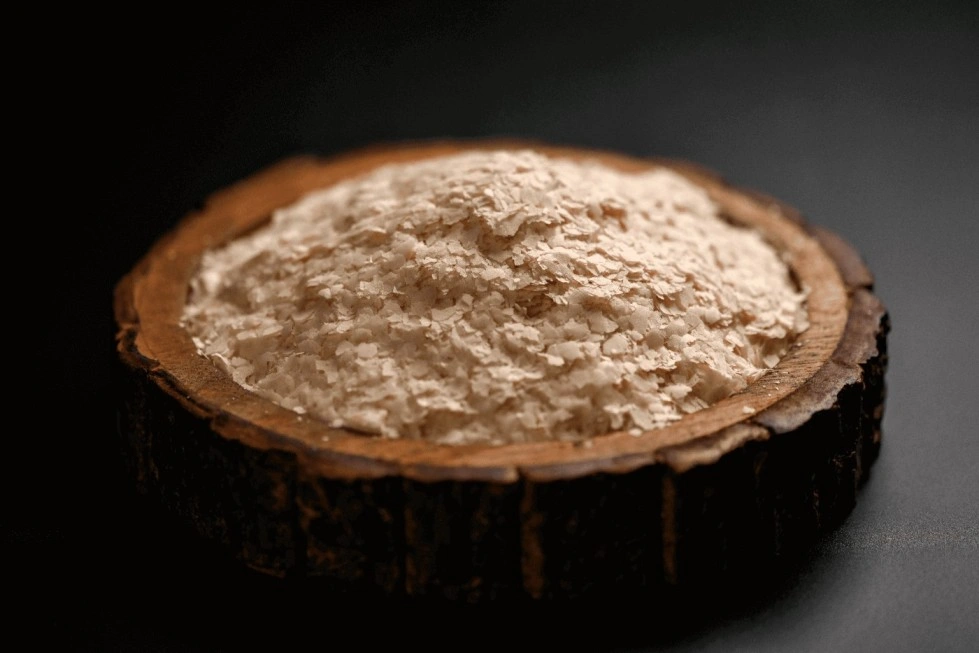 A bowl of potato flakes dark background