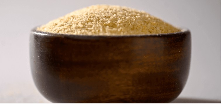 A close-up of a bowl filled with yellow powder, which is potato granules.