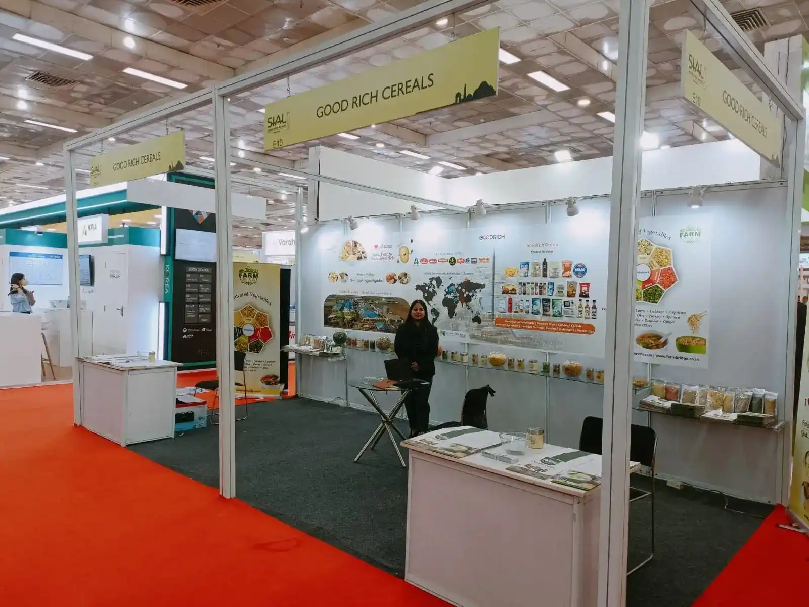 A woman stands in front of a large exhibition booth at the Goodrich Exhibition Sial.