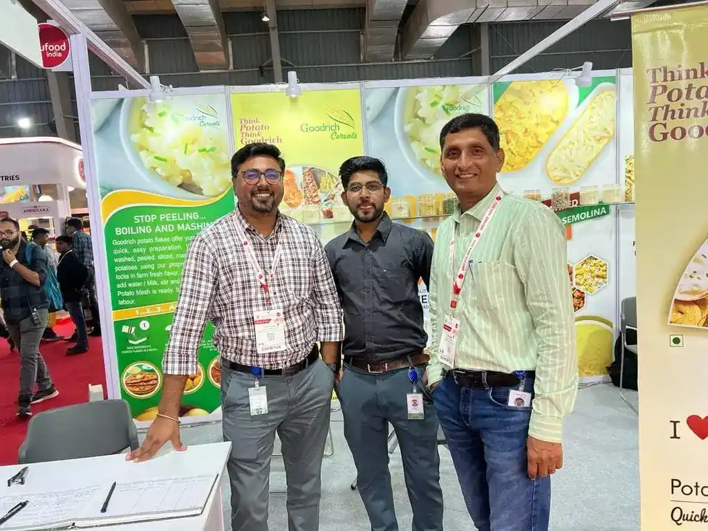 Three men at Goodrich exhibition Anuga Mumbai, standing together.