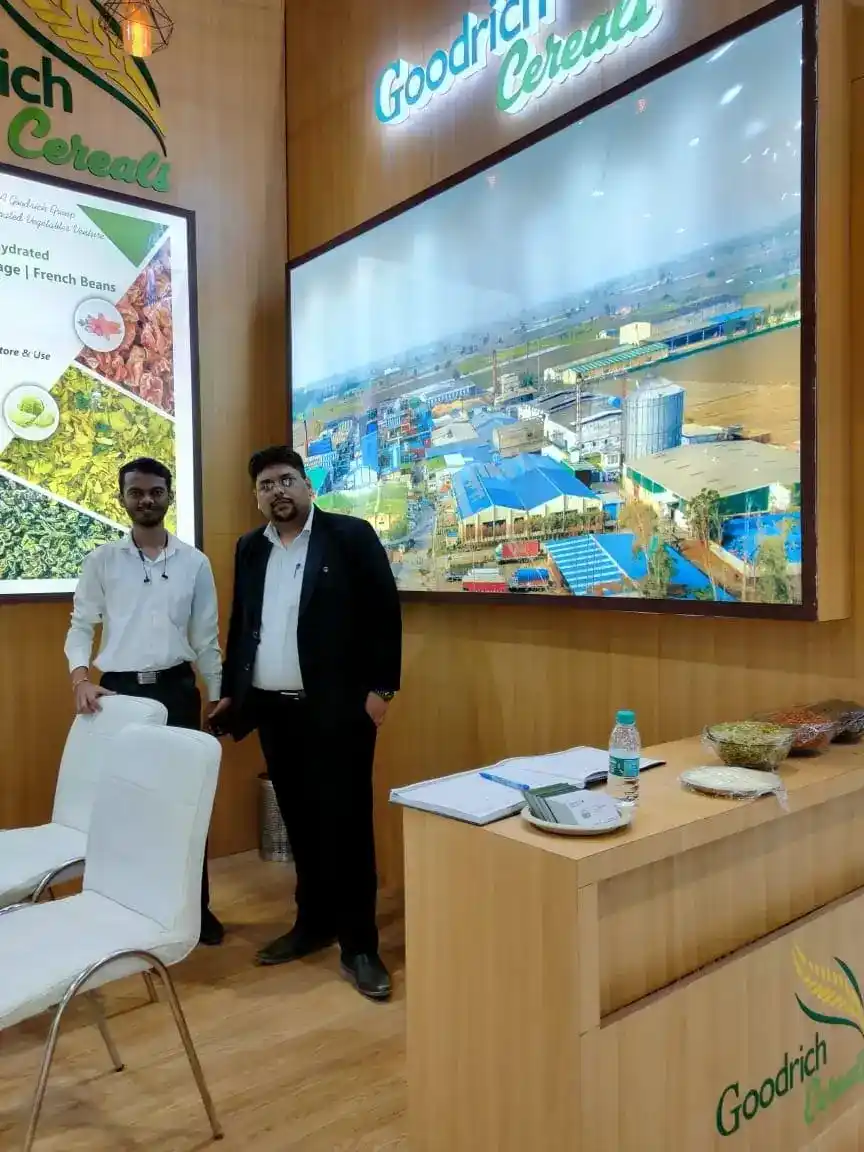 Two men at the Goodrich exhibition Aahar India, standing in front of a display of food products.